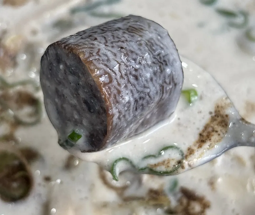 숟가락으로 떠올린 부드러운 크림순대국밥