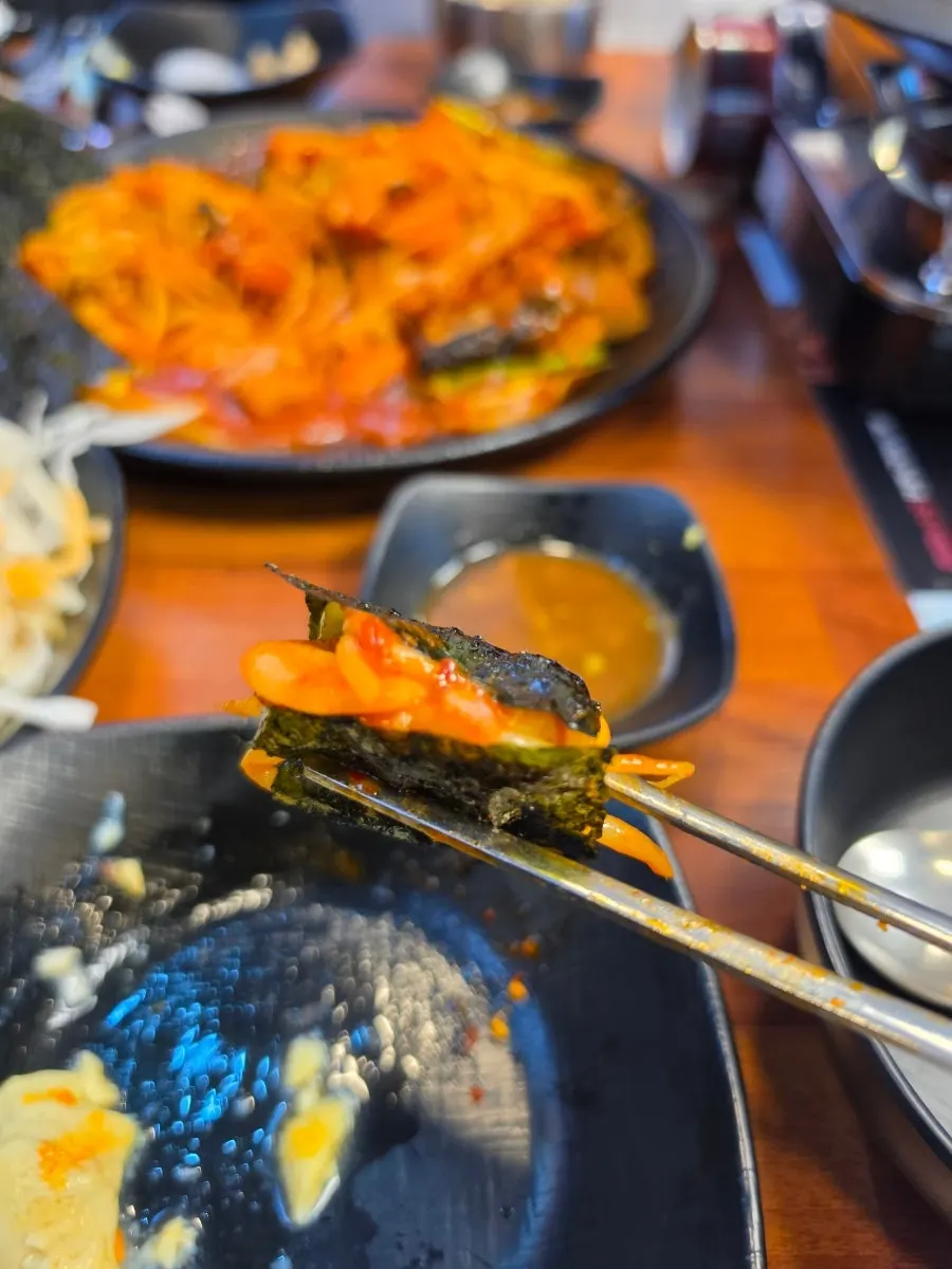 A bite of monkfish meat and bean sprouts lifted up together