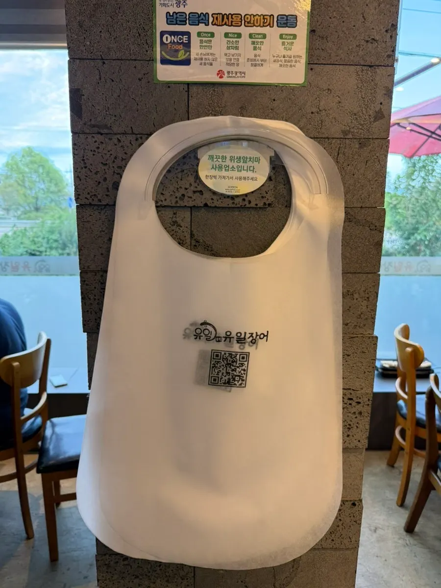 Cups, tableware, and a disposable apron set up at the table