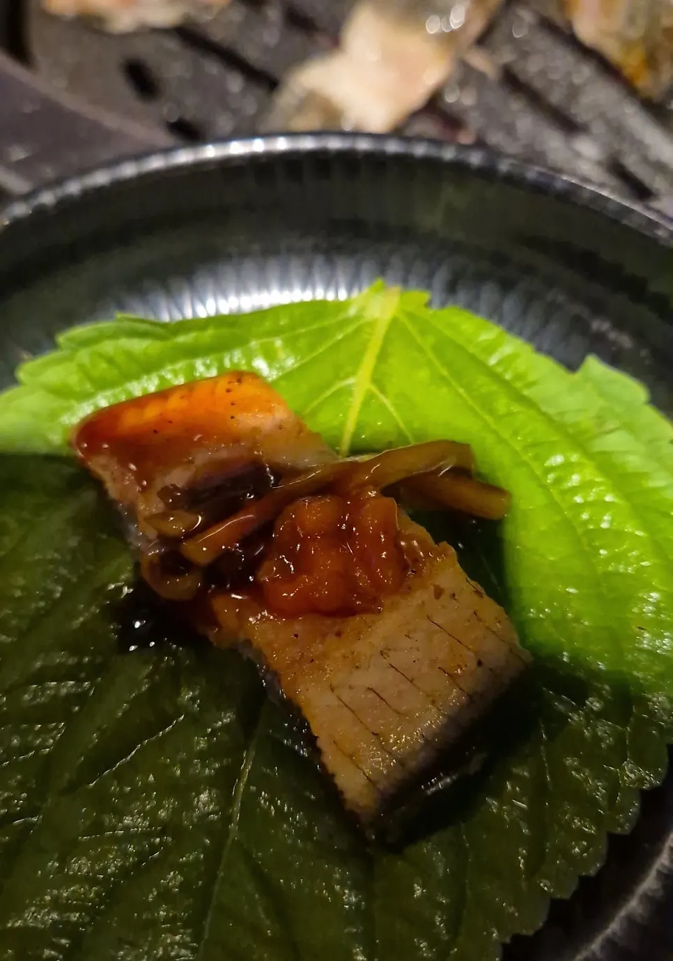 A piece of eel picked up with tongs