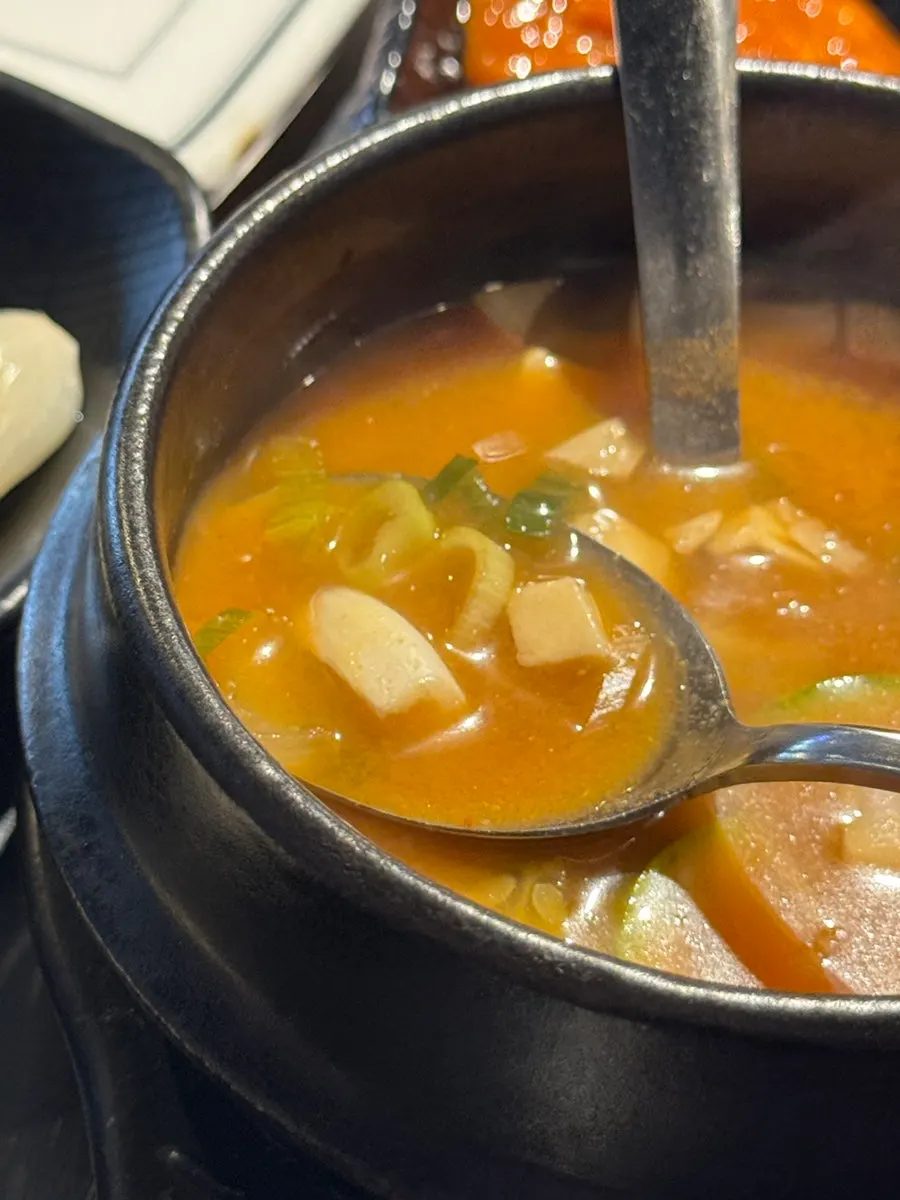 Taking a spoonful of doenjang jjigae