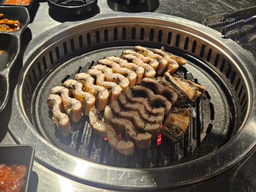 Pre-grilled freshwater eel placed on the charcoal grill