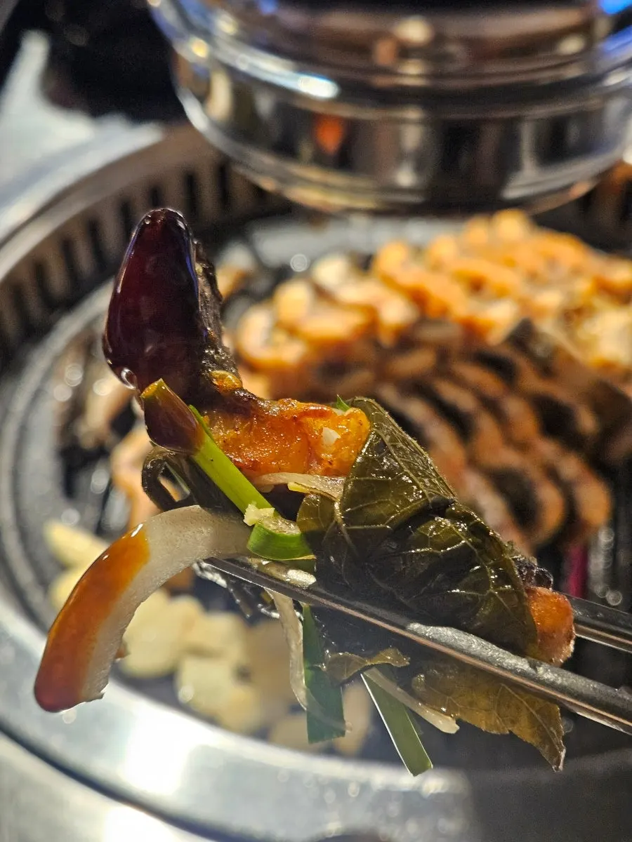 Eel dipped in eel sauce paired with perilla leaf