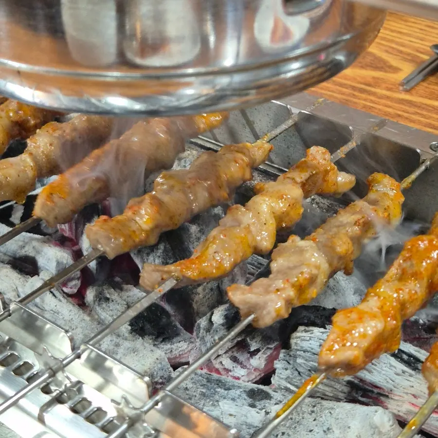 자동으로 돌아가는 숯불 불판 위 양꼬치
