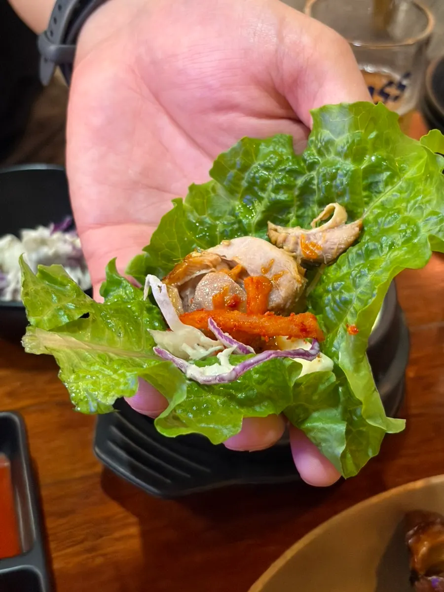 A wrap of garlic jokbal with vegetables