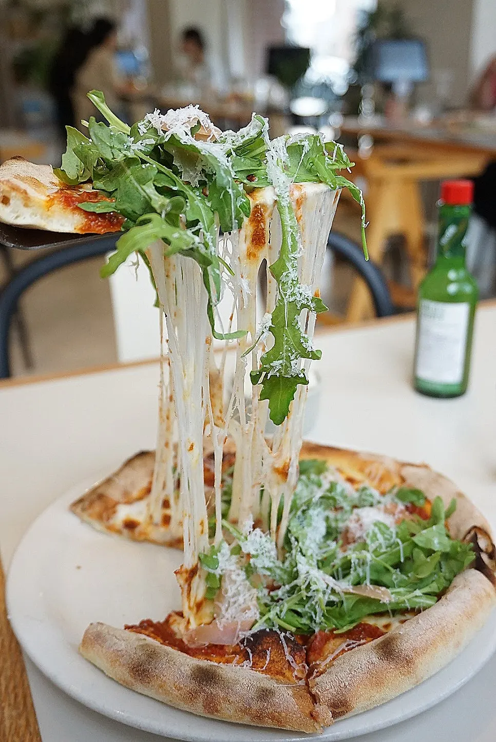 Cheese on the freshly served arugula pizza