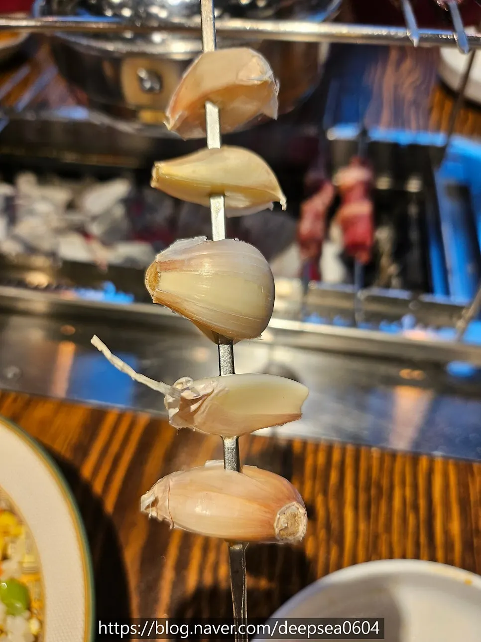 Skewering whole garlic onto an empty stick