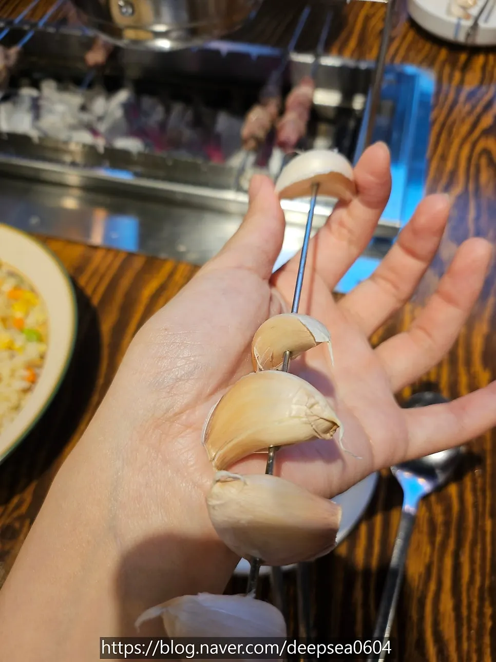 Skin-on garlic on a skewer placed on the grill