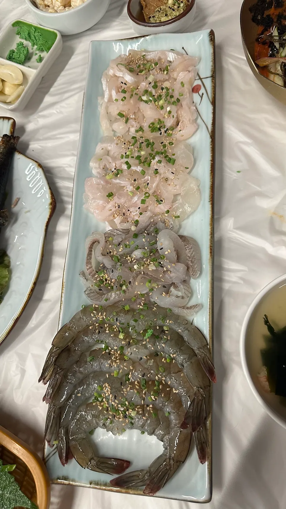 Main set of raw shrimp and live fish sashimi
