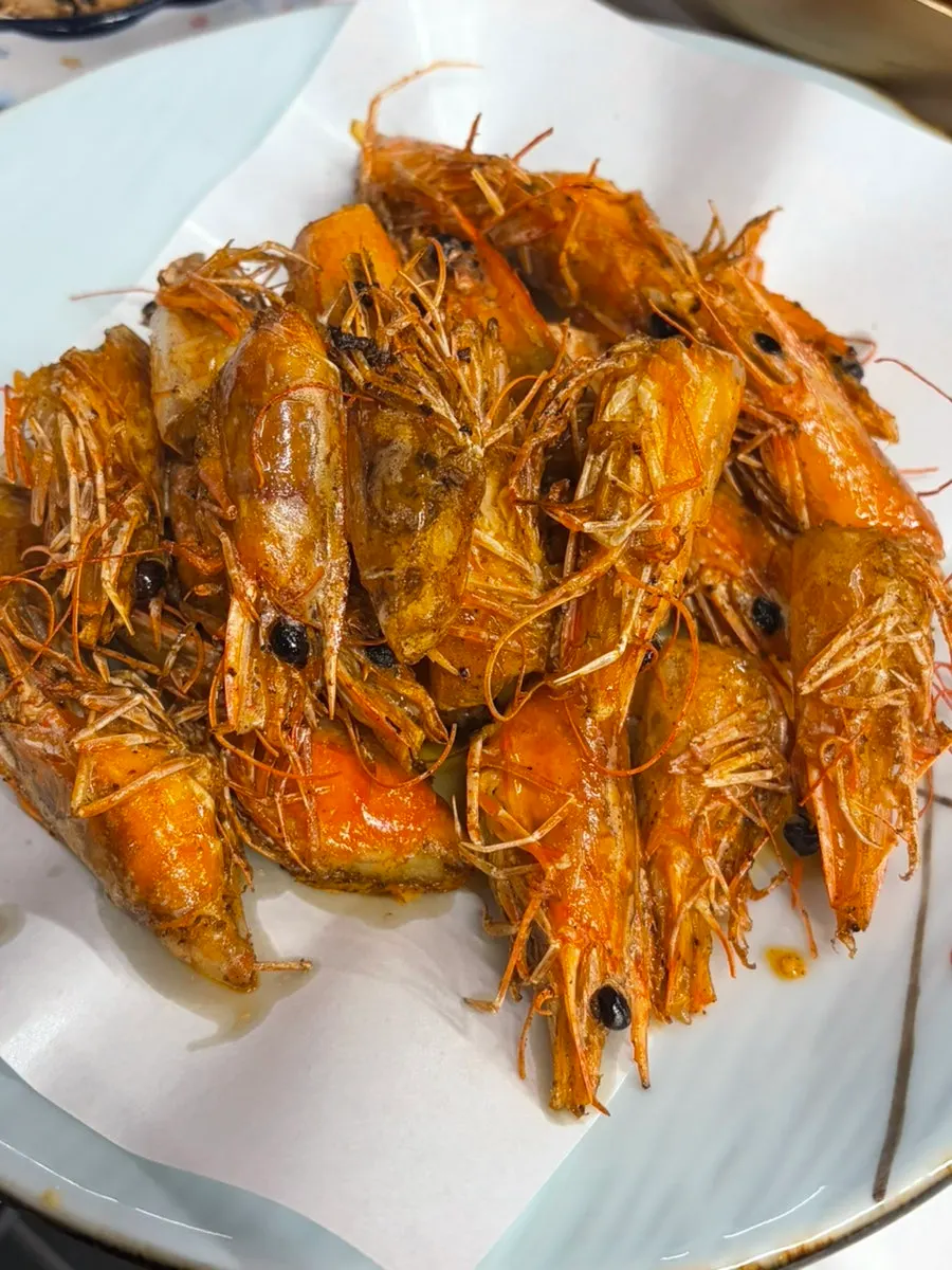A piece of grilled king shrimp over rice