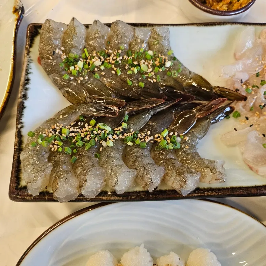 Raw fish sashimi and soybean powder salad wrapped in perilla leaf
