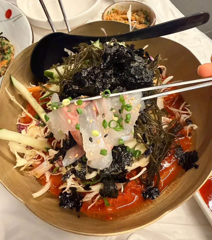 Table loaded with mixed sashimi and side dishes at a Wolsan-dong sashimi restaurant
