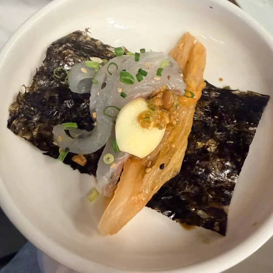 A bite of sashimi wrapped in lettuce