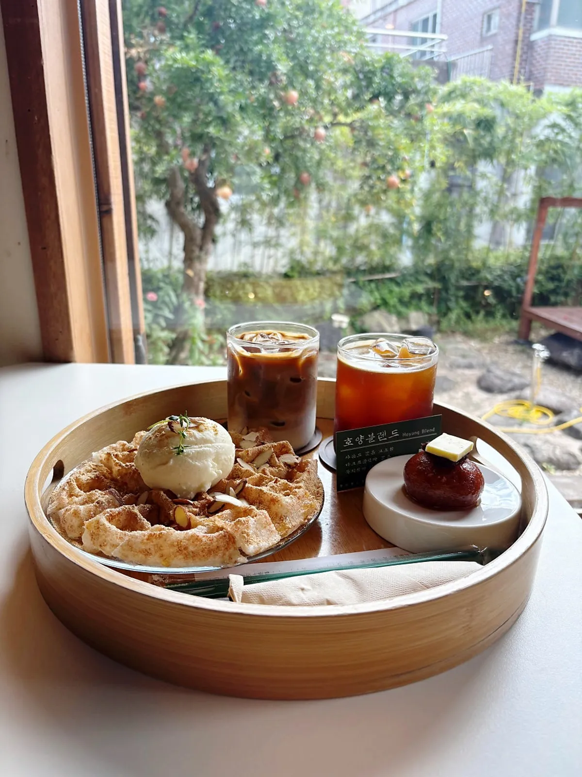 Gaeseongjuak, injeolmi waffle, and coffee plated together