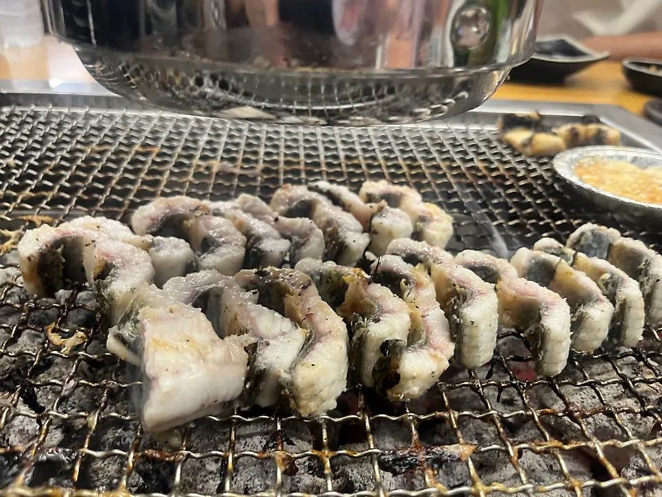 Eel grilling golden brown over charcoal