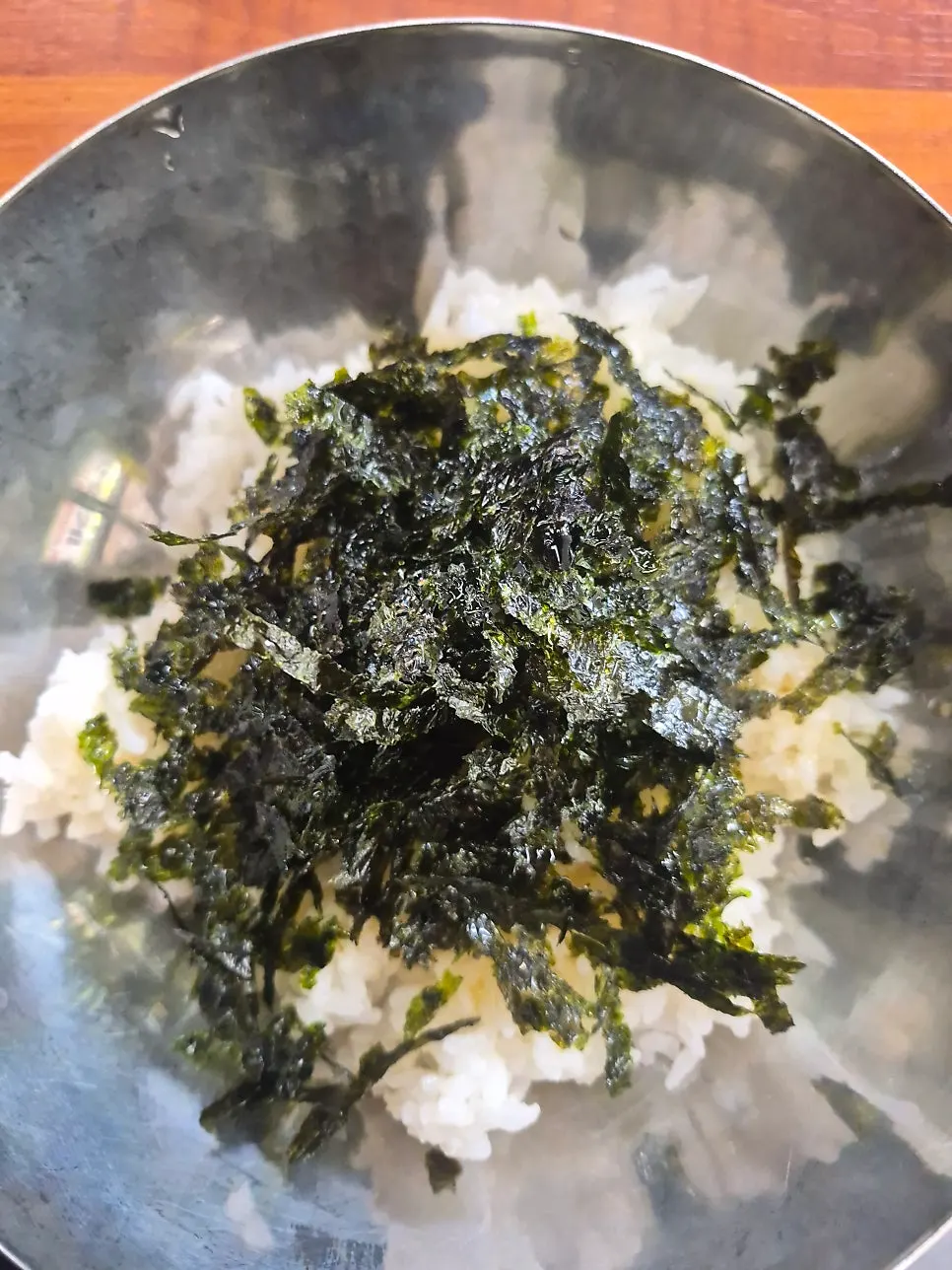 Mixing gopchang hot pot broth into daejeopbap topped with seaweed flakes