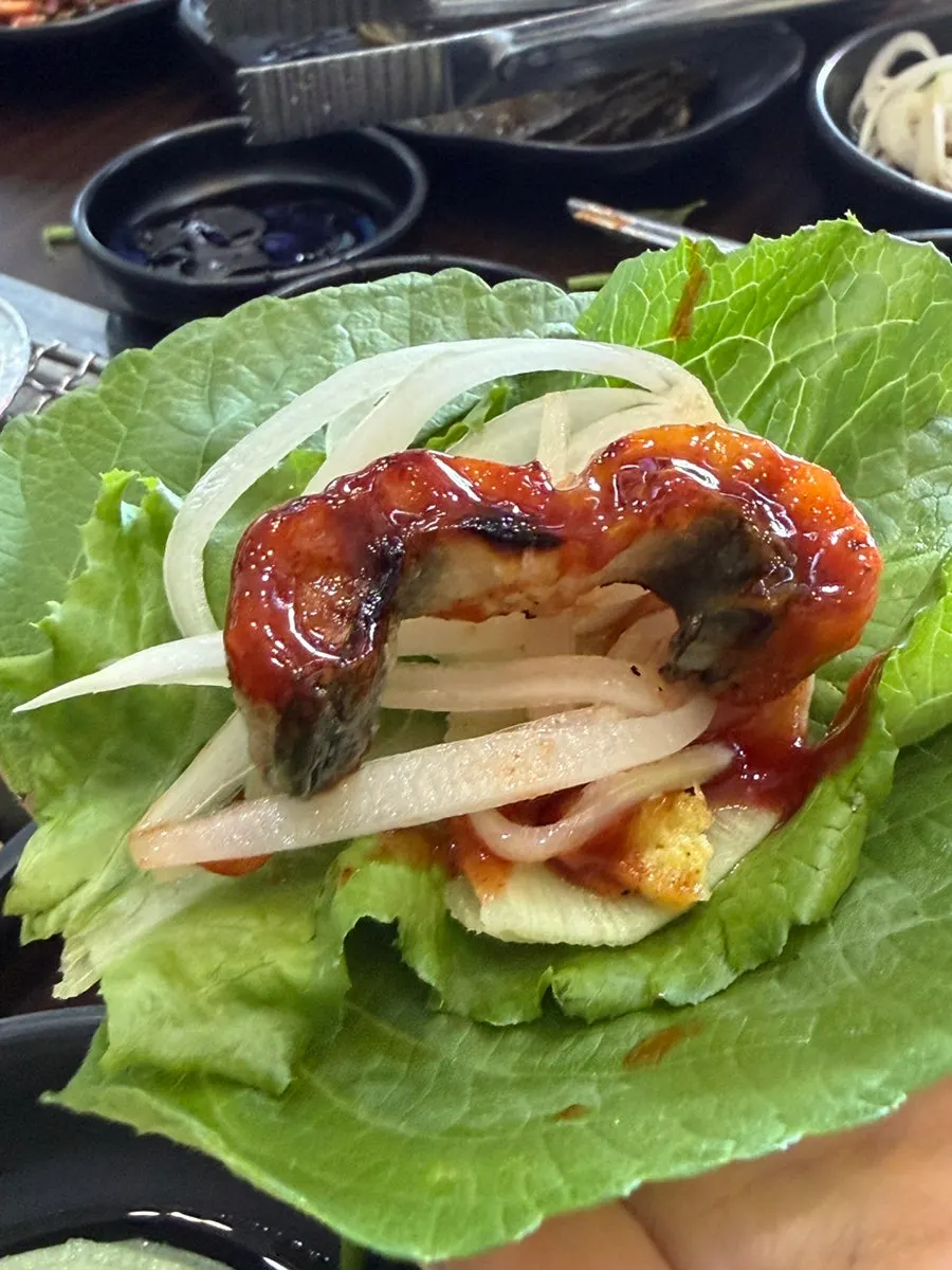 Wrapping grilled eel in lettuce