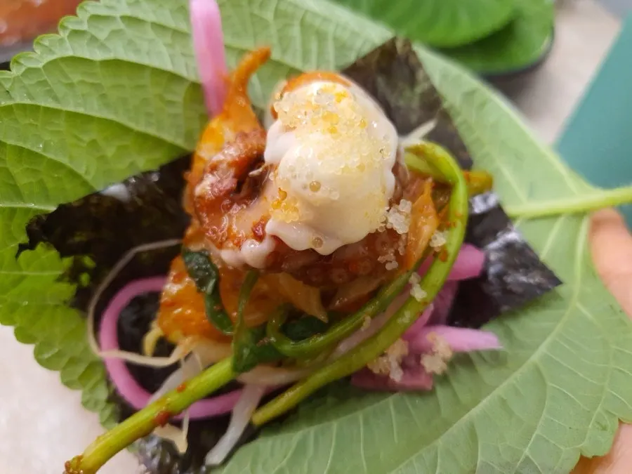 Trozo de jjukkumi con salsa blanca y huevas de pez volador