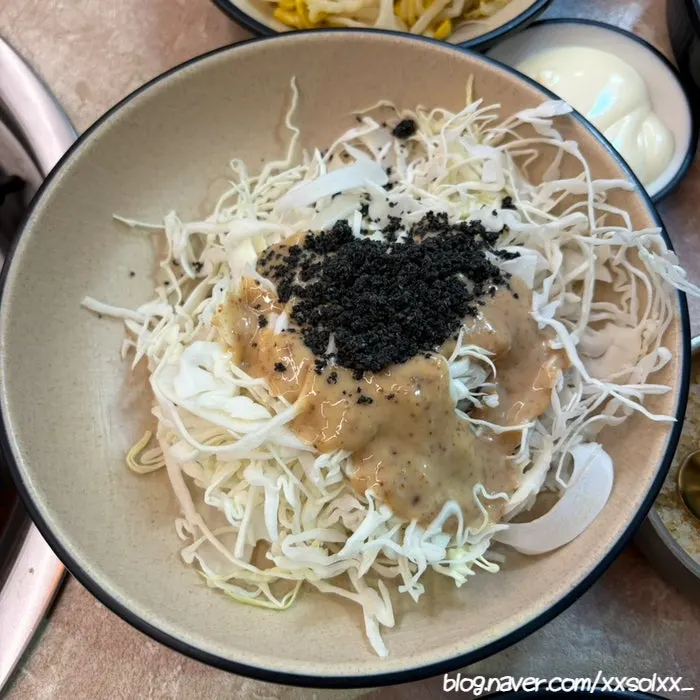 Side dishes of bean sprouts, sesame leaves, pickled radish, seaweed, and flying fish roe
