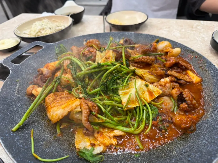 Staff member cooking the hot-plate jjukkumi
