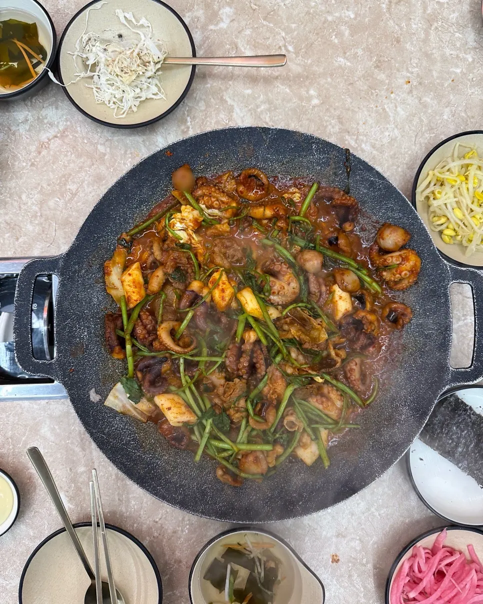 Jjukkumi and minari cooking on the hot plate