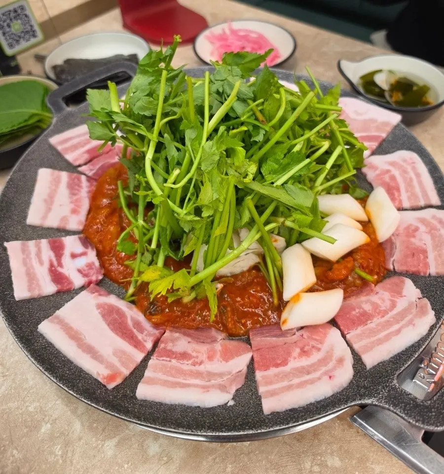 Griddled jjukkumi with extra toppings and black pork belly set up