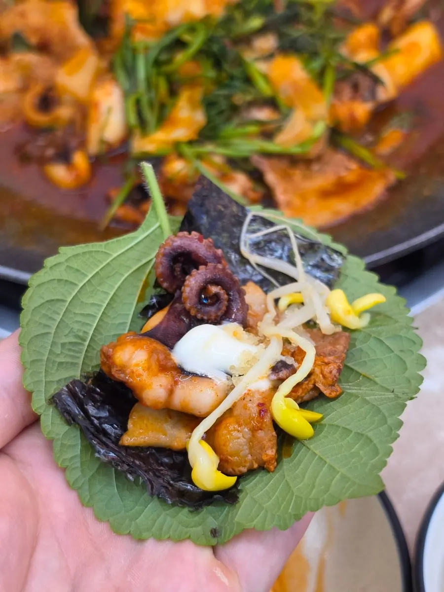 Jjukkumi wrap topped with flying fish roe and radish strips