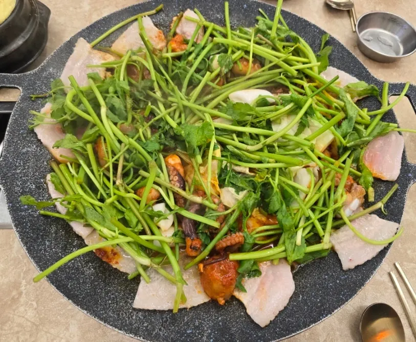 Jjukkumi and pork belly visible beneath the minari