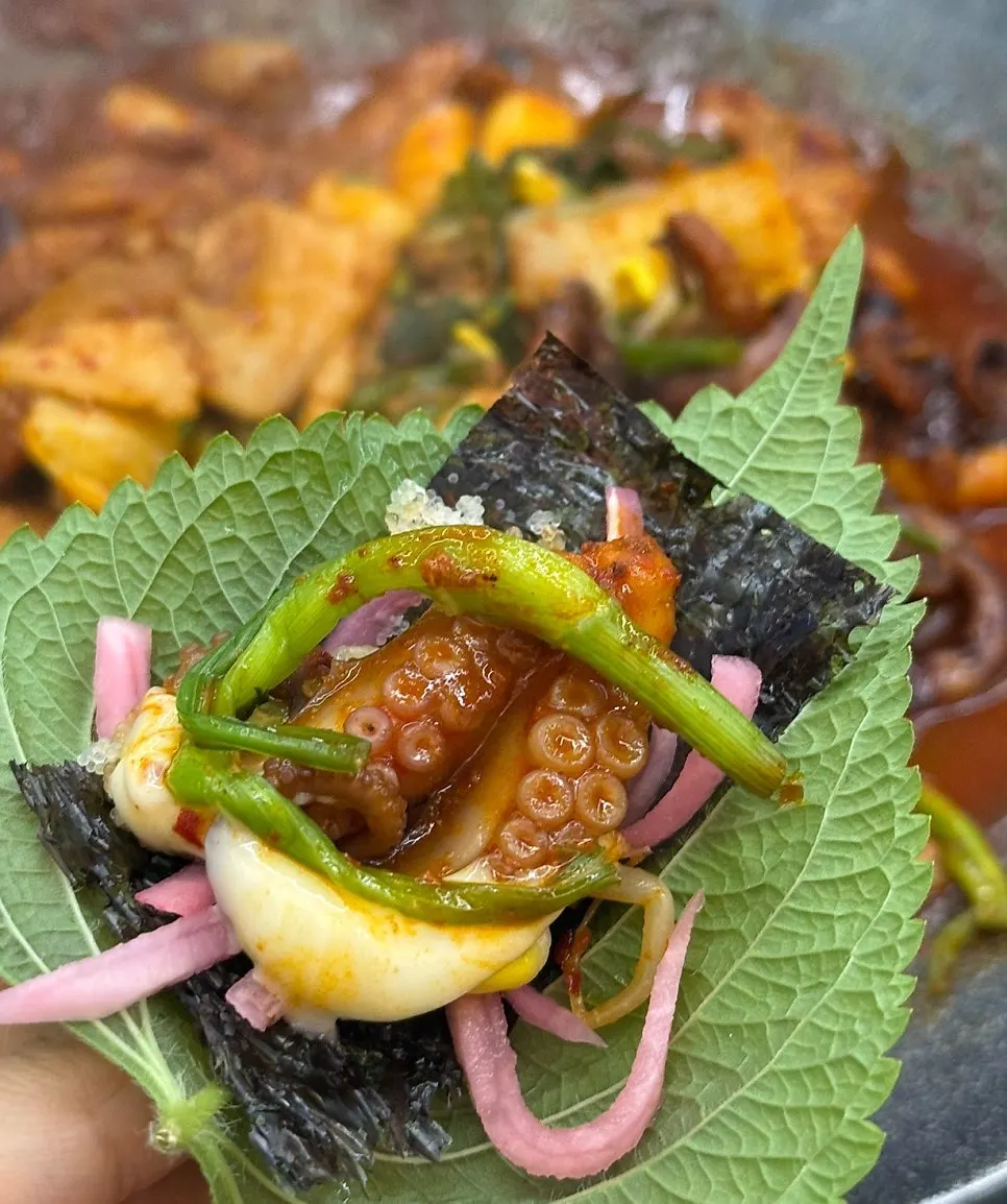 Jjukkumi wrap in a sesame leaf topped with flying fish roe