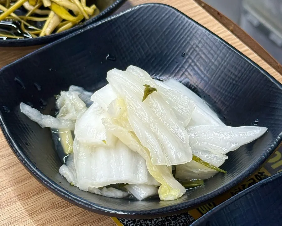 Side dishes including garlic scapes served with the chicken stew
