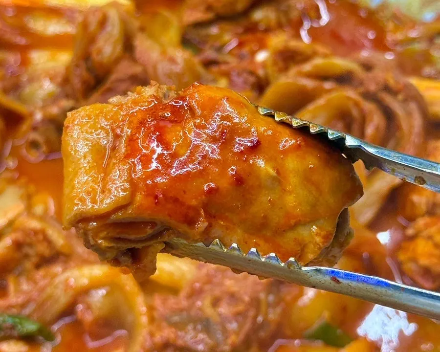 Wrapping chicken meat in aged kimchi to eat