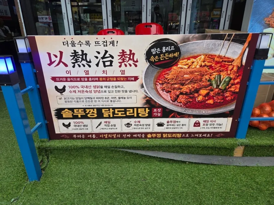 Store sign introducing domestic chicken and cast-iron pot lid cooking