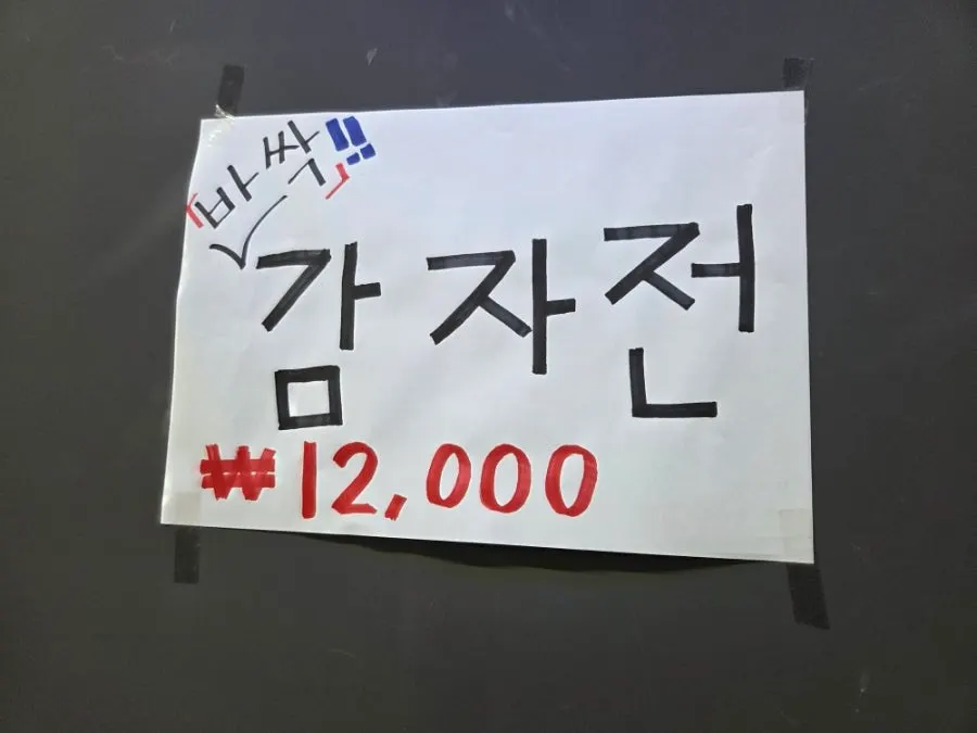 Menu board showing potato pancake and other extras