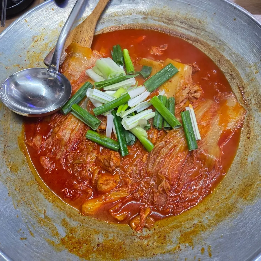 Aged kimchi chicken stew served in a cast-iron pot lid