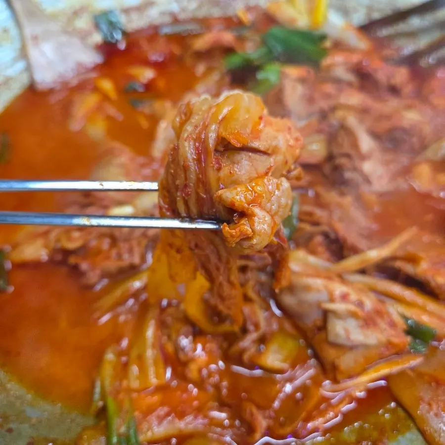 Chicken wrapped in aged kimchi being eaten