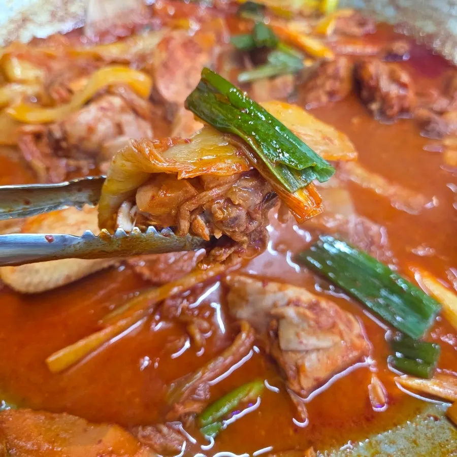 Cast-iron pot lid nearly emptied of meat