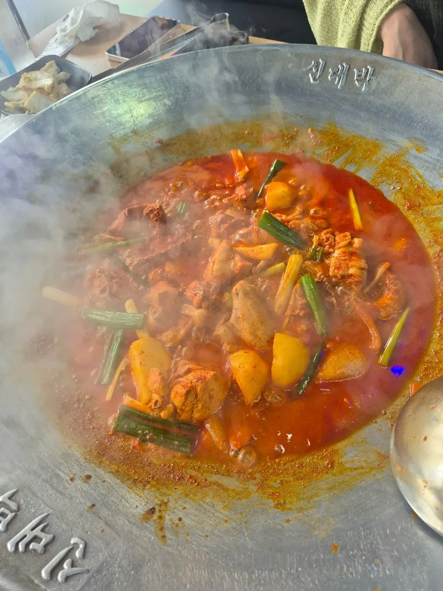Large cast-iron lid chicken stew for two cooking over the flame