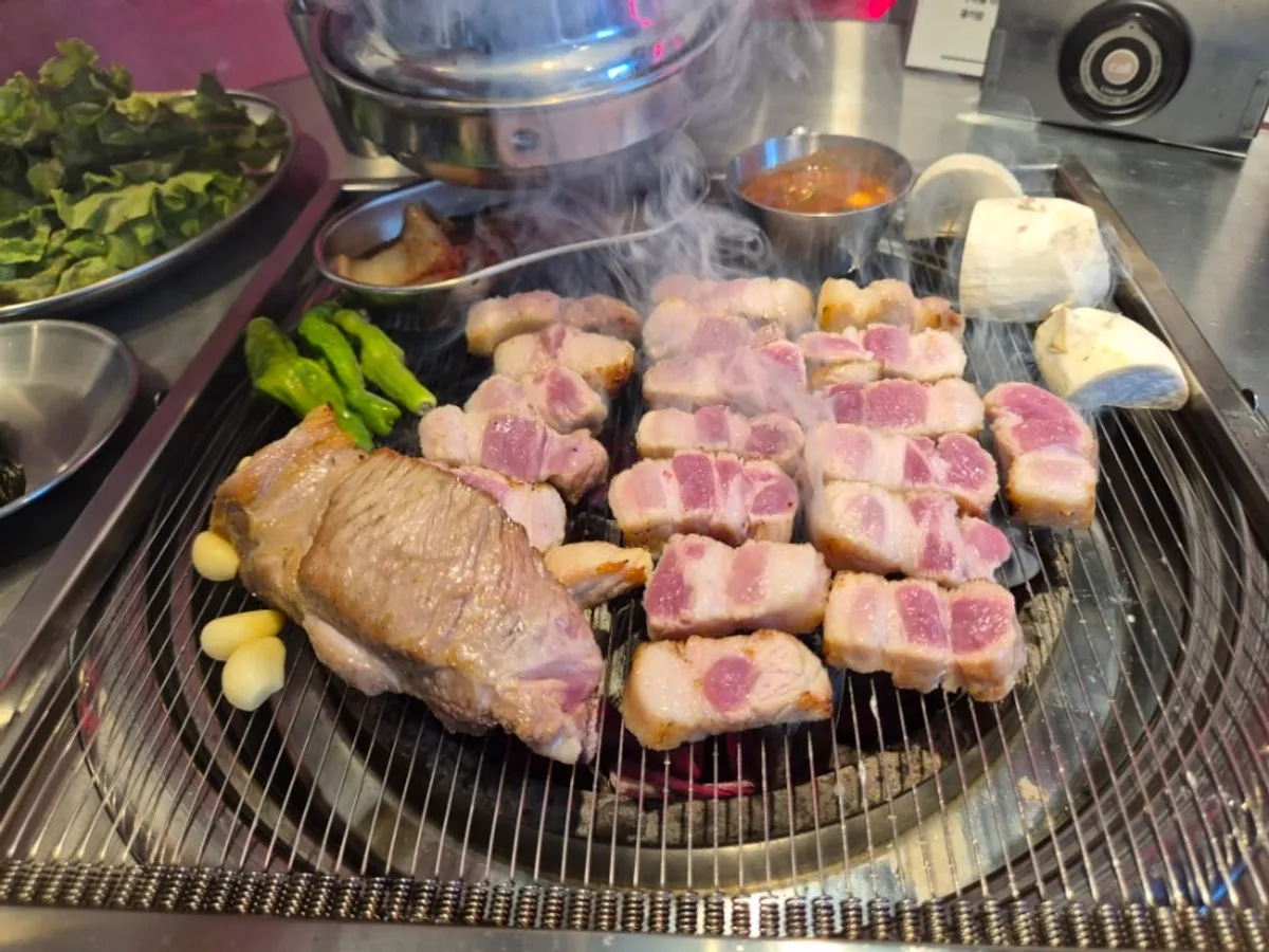 Pork belly grilling on the tabletop grill with juices flowing