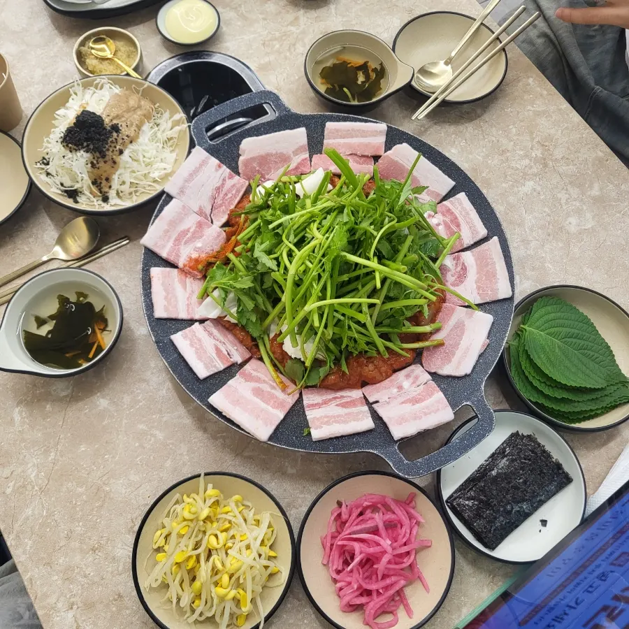 Two servings of sari-deumbuk black pork flower belly on the griddle