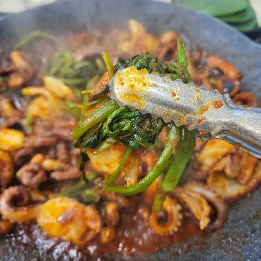 Jjukkumi and cabbage cooking on the griddle