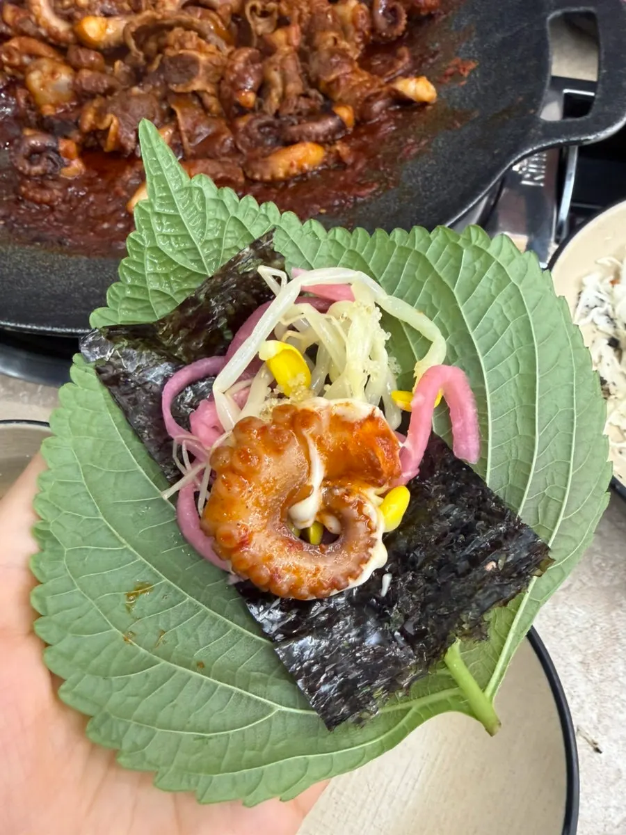 Sesame leaf wrap of jjukkumi eaten as suggested