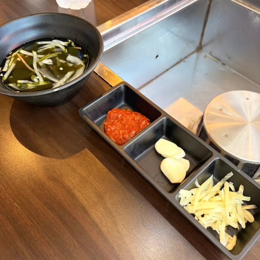 Full table setting with basic side dishes served alongside the eel
