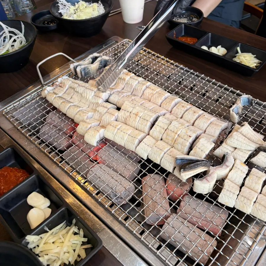 Pre-grilled freshwater eel placed on the charcoal grill