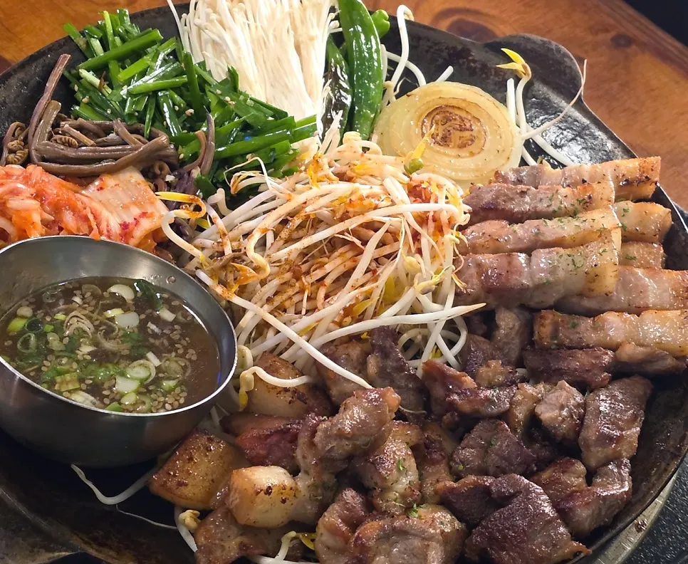 Spicy sauce poured over the bean sprouts in the center of the grill