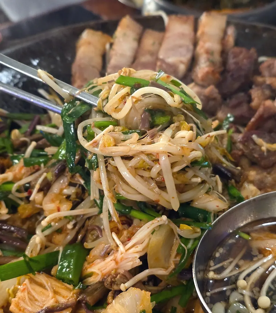 Black pork samgyeopsal grilling over charcoal