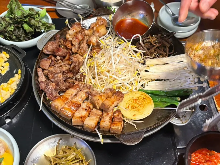 Half order of assorted pork cuts served on a pot-lid-shaped grill
