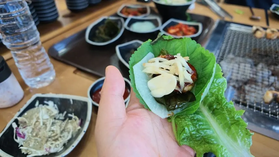 소금과 소스에 곁들여 먹는 장어구이 한 점
