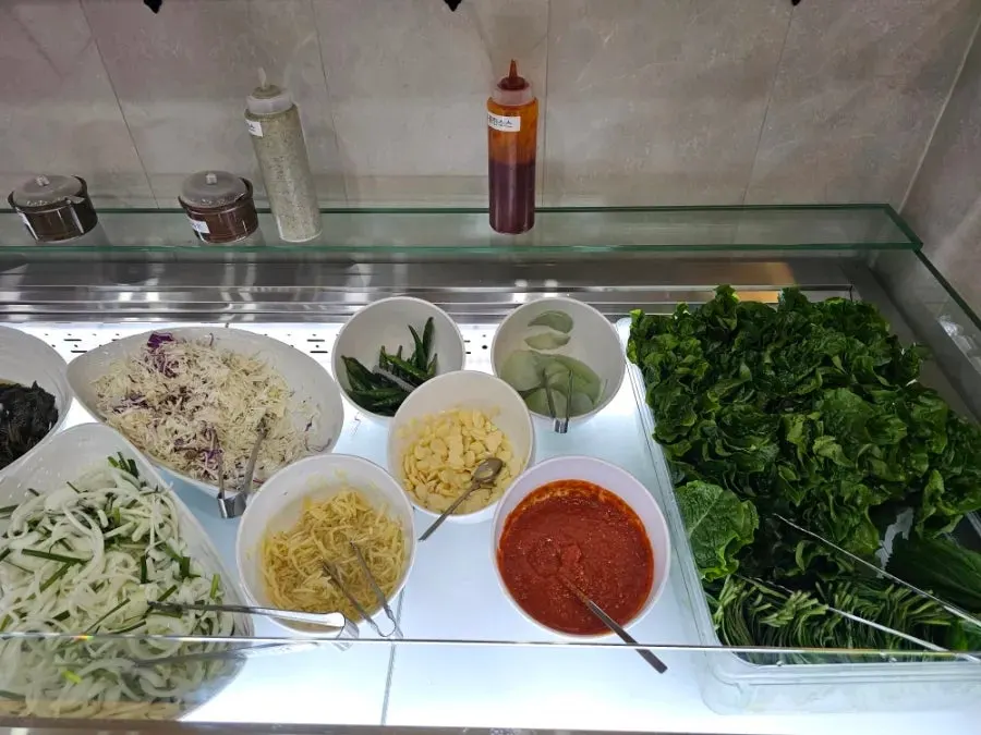 Wrapping greens and sauces stocked at the self-serve bar