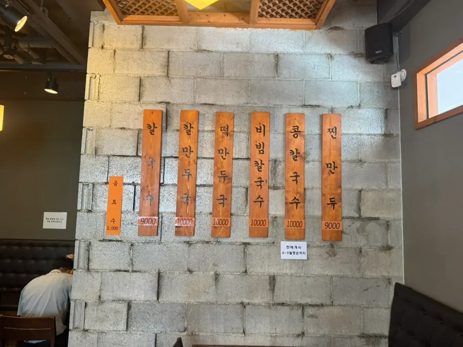 Glass-walled kitchen showing dumplings being hand-folded