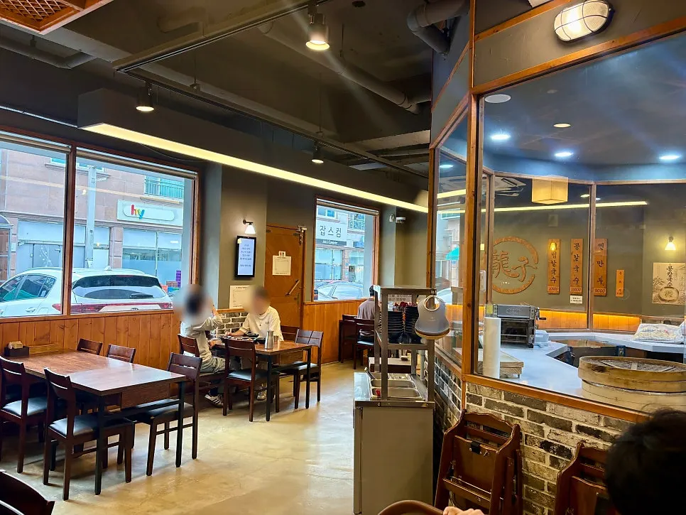 Restaurant with a wooden sign and visible noodle-making area